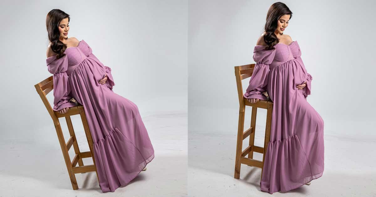 Pregnant woman sitting on a chair in a studio maternity photoshoot with corrected posture and refined posing angle