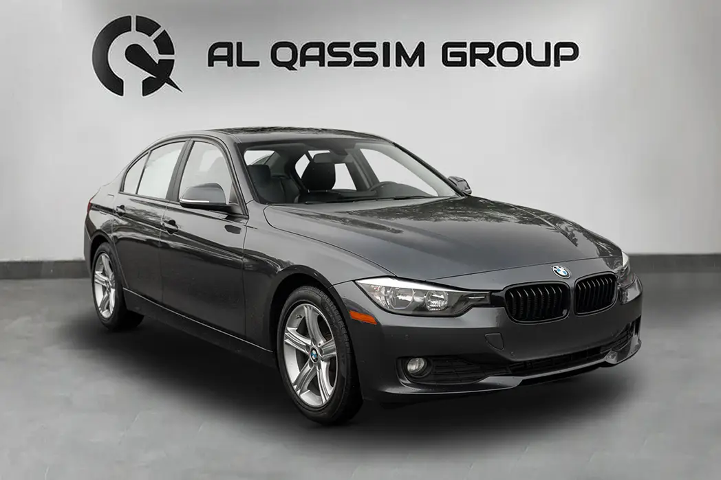 Grey BMW sedan with Al Qassim Group branded showroom background