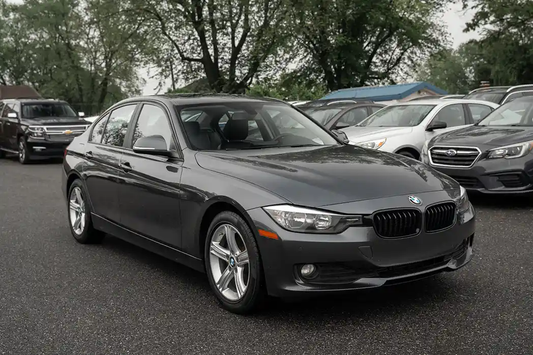 Grey BMW sedan with Al Qassim Group branded showroom background