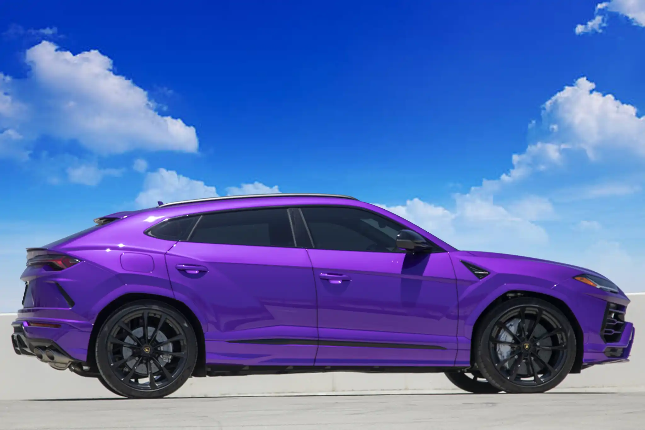 Purple Lamborghini Urus side view after blue sky replacement edit